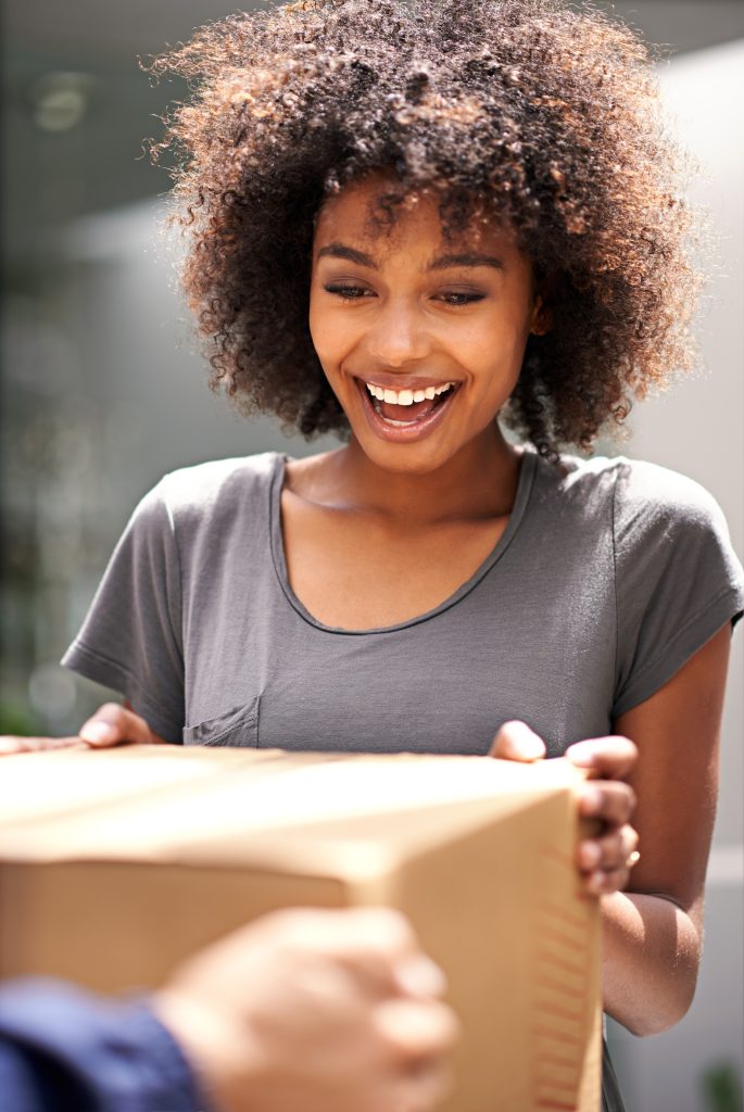 Joyful woman receiving a package with a smile.